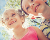 Two children happy and smiling demonstrating how good it feels to be in tune with their emotions through somatic awareness.
